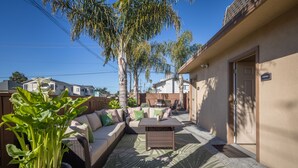 Un patio con un sofá, una mesa y plantas en macetas.