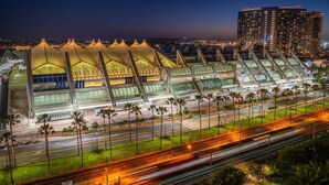 A modern stadium with a unique roof structure, surrounded by palm trees and a busy road with light trails. - Old Town Western Inn & Suites (San Diego)