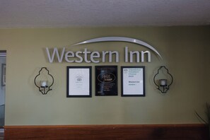 A wall with the text "Western Inn" and three framed awards. - Old Town Western Inn & Suites (San Diego)