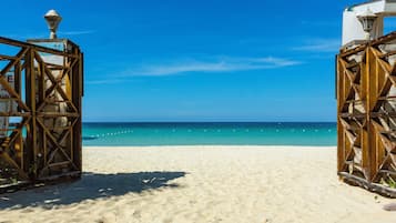 Am Strand, weißer Sandstrand, Liegestühle, Sonnenschirme
