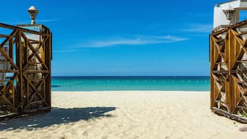 On the beach, white sand, sun-loungers, beach umbrellas