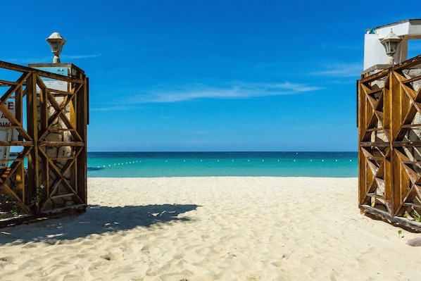 Accommodatie ligt op het strand, wit zand, ligstoelen, parasols