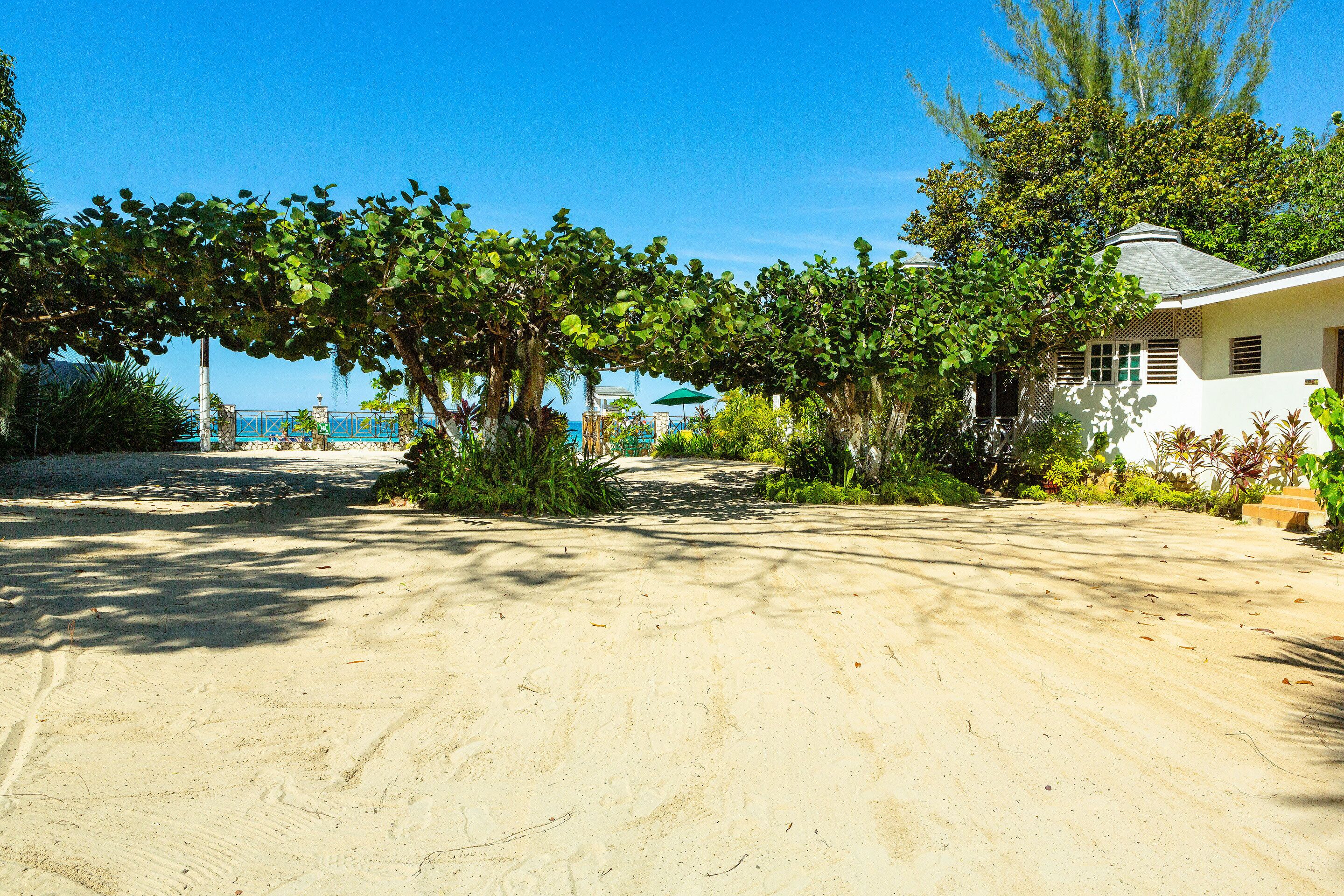 Na praia, areia branca, espreguiçadeiras, guarda-sóis 