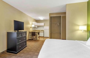 A hotel room with a bed, a desk, a television, a wardrobe, and a closet. - Studio 6 Extended Stay Chicago Vernon Hills Lincolnshire IL (Vernon Hills)