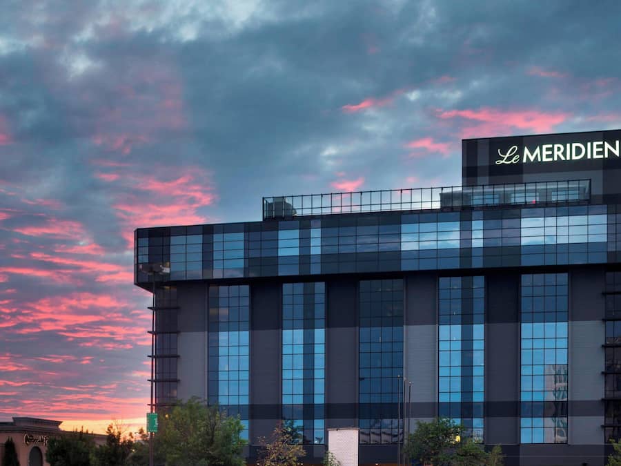 A modern building with a glass facade and a sign reading "Le MERIDIEN".