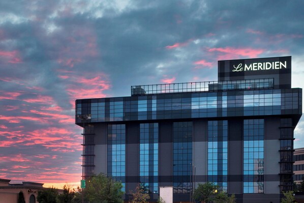A modern building with a glass facade and a sign reading "Le MERIDIEN".