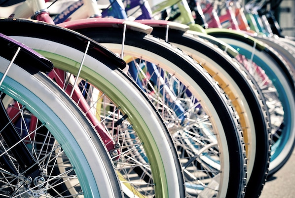 A row of bicycles with various colored tires and metal spokes.