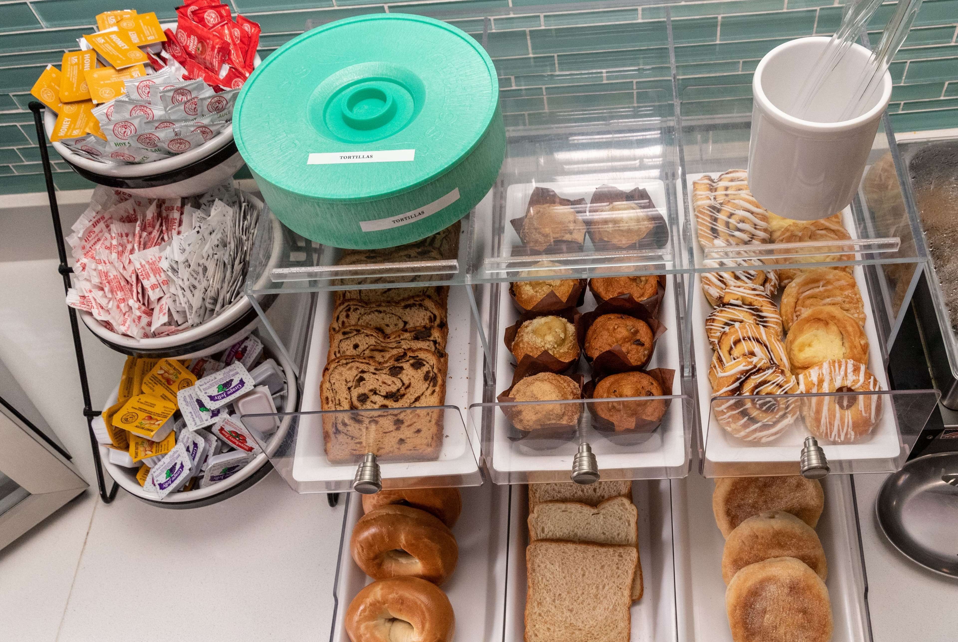 A bakery display with various baked goods including tortillas, muffins, pastries, and bread.