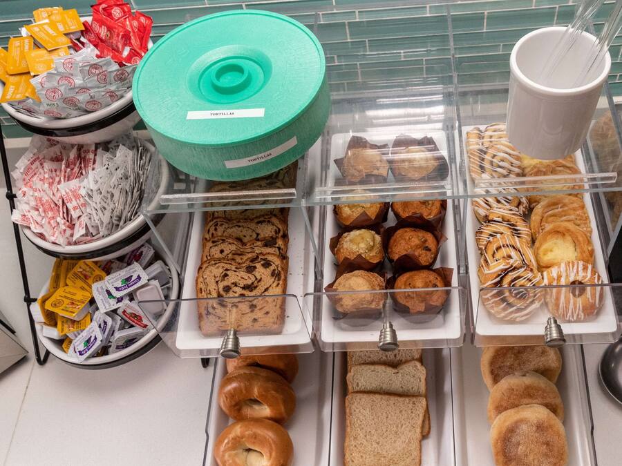 A bakery display with various baked goods including tortillas, muffins, pastries, and bread.