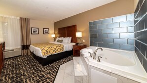 Ein Hotelzimmer mit einem Bett, einem Badezimmer mit einer Badewanne und einem gemusterten Teppich.