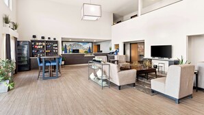 A spacious living area with a modern kitchen, a dining table with chairs, a sofa, and a flat-screen TV. - Best Western Snowflake Inn (Snowflake)