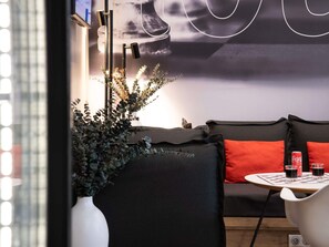 En modern inredning med en soffa, ett bord med drycker och en prydnadsväxt.