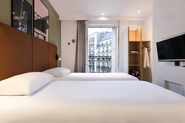 Relax in a spacious room with a large bed, flat-screen TV, and wardrobe, plus a balcony with city views.