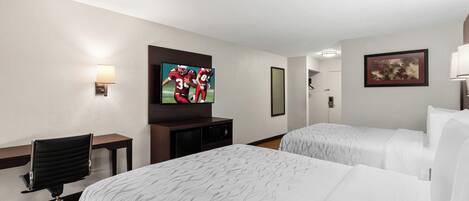 Una habitación de hotel con dos camas, un escritorio, un televisor y una silla.