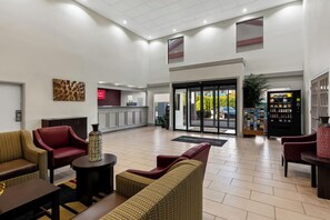 A lobby with seating, a reception desk, and a vending machine.