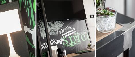 A modern interior with a black-framed display, a glass container with ice, and a wooden counter.