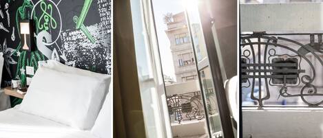 A bed with white linens, a nightstand with a lamp, and a wall with a green and white abstract design.