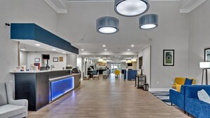 A hotel lobby with a reception desk, seating area, and a view into the dining area. - Comfort Suites Salisbury I-85 (Salisbury)