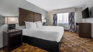 A hotel room with a large bed, bedside tables, a flat-screen TV, and a window with curtains. - Best Western Plus Whitewater Inn (Harrison)