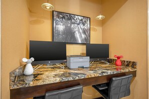 A hotel room with a marble countertop, two monitors, a Brother printer, a white mouse figurine, and a red vase. - Best Western Plus Whitewater Inn (Harrison)