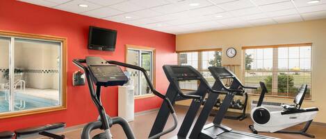 A gym with treadmills, a stationary bike, and a weight bench.