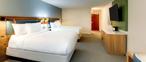 Habitación de hotel con una cama grande, una mesita de noche, un televisor montado en la pared y un armario de madera.