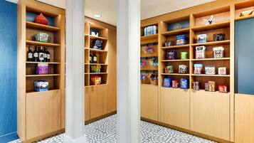 A modern hotel lobby with wooden shelving units displaying various items.