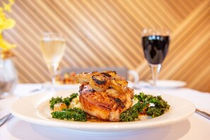 Un plato de comida con una copa de vino blanco y una copa de vino tinto sobre la mesa.