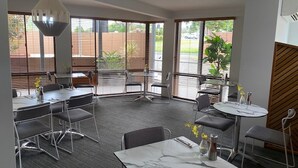 A modern conference room with large windows, a marble table, and contemporary furniture. - Quality Hotel City Centre (Coffs Harbour)