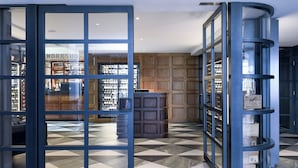 A modern interior with a checkered floor, a wooden panel wall, and a glass display case with items. - Powerhouse Hotel Tamworth by Rydges (Tamworth)