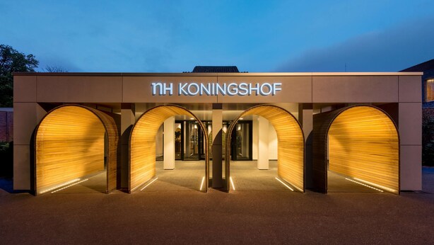 The exterior of NH Koningshof hotel with a modern design, featuring three large arched entrances and a prominent sign. - NH Eindhoven Conference Centre Koningshof (Veldhoven)