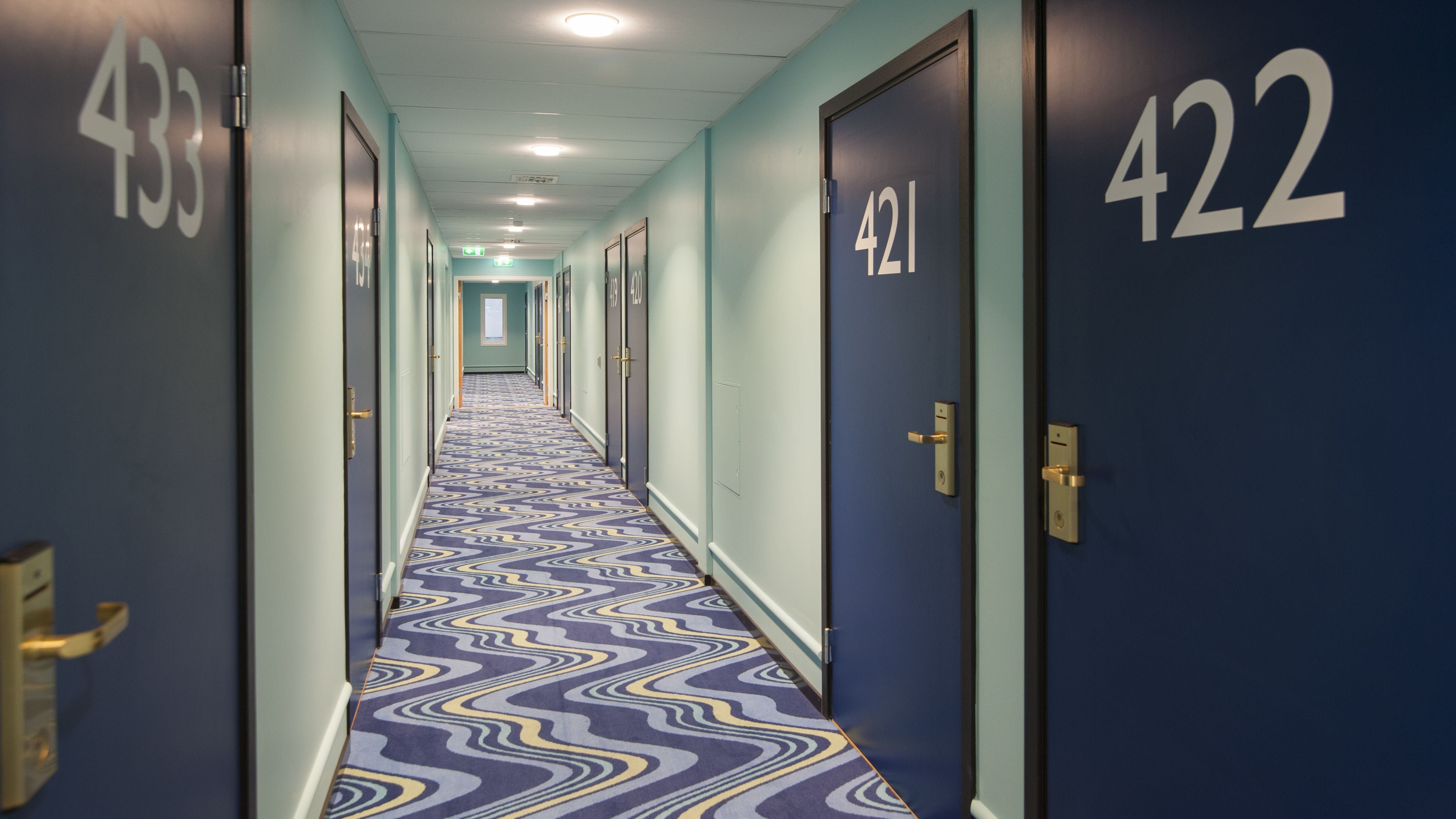 Un pasillo de hotel con puertas numeradas 433, 421 y 422.