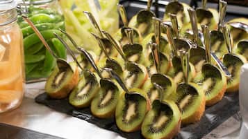 A tray of sliced kiwi arranged on a black slate board.