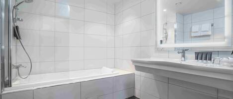 A modern bathroom with a glass-enclosed shower, a freestanding bathtub, and a large mirror above the sink.