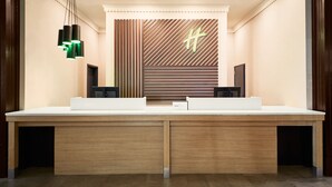A reception desk with a modern design, featuring a wooden finish and a central logo.
