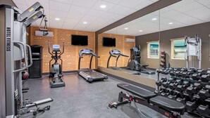 Palestra alberghiera con tapis roulant, macchinari per pesi e manubri.