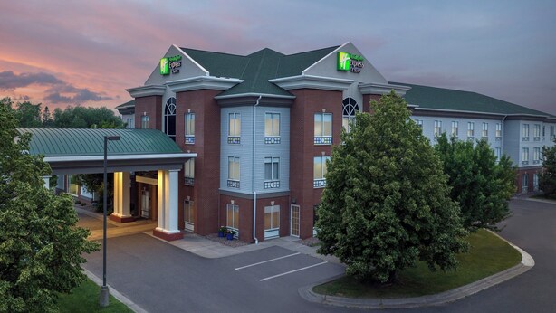 Un hôtel à plusieurs étages, doté d’une façade en briques et d’un toit végétalisé, sur lequel on peut voir une enseigne Holiday Inn Express.