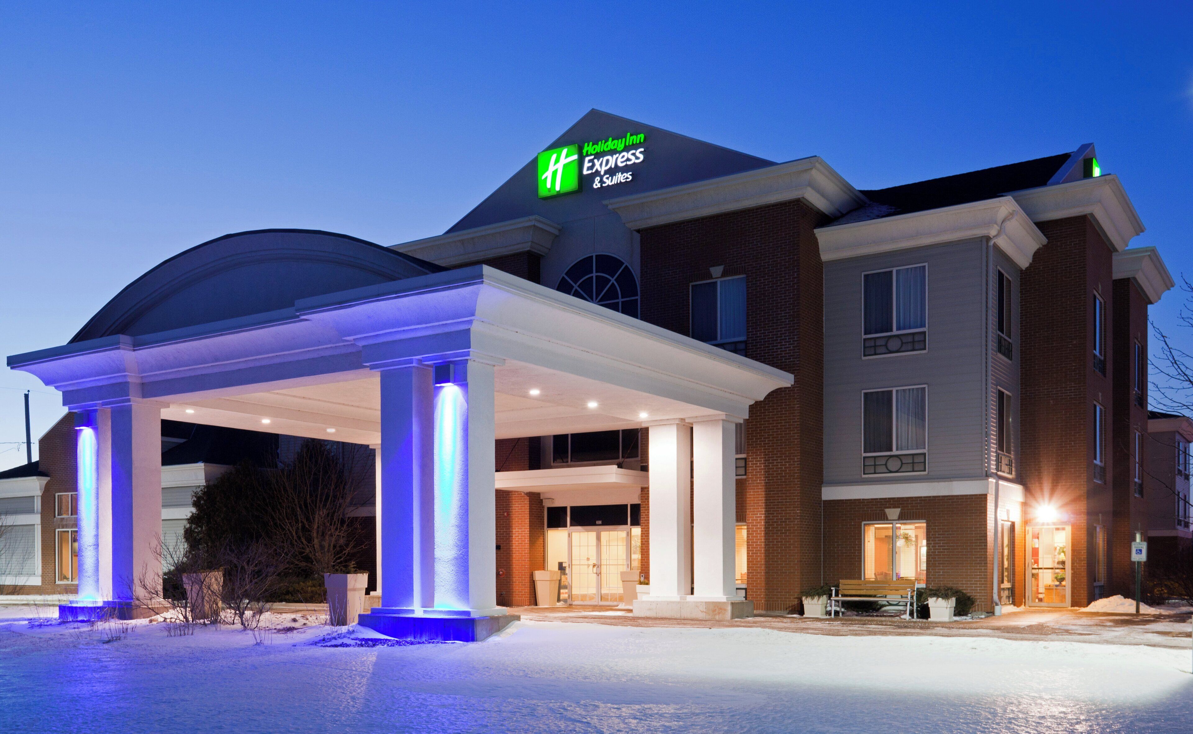 Edifício Holiday Inn Express com entrada coberta e chão coberto de neve.