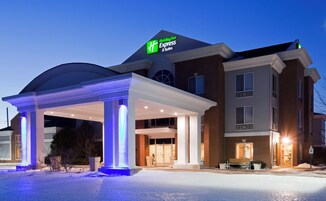 Edificio de Holiday Inn Express con un acceso cubierto y el suelo cubierto de nieve.