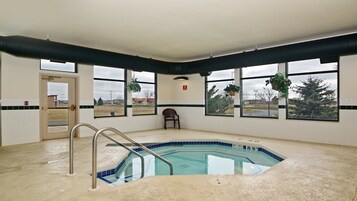 Una piscina con vistas despejadas al exterior, una silla y una puerta.
