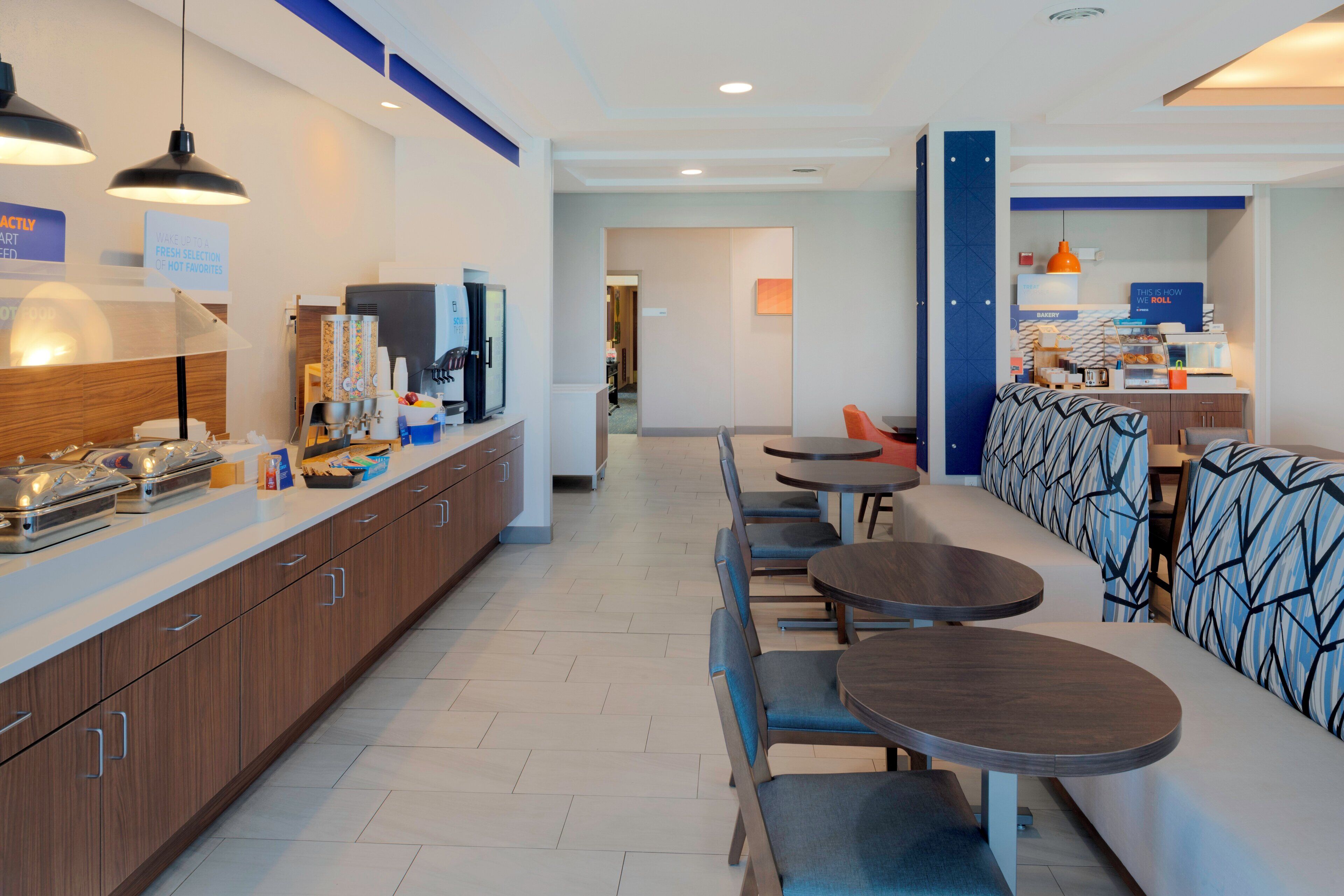 Eine moderne Hotelhalle mit langer Theke, Sitzgelegenheit und einer Küchenzeile.