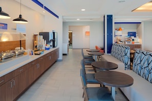 A modern hotel lobby with a long counter, seating area, and a kitchenette. - Holiday Inn Express Hotel & Suites Fort Atkinson by IHG (Fort Atkinson)