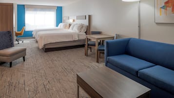 Suite, varias camas | Caja de seguridad en la habitación y escritorio