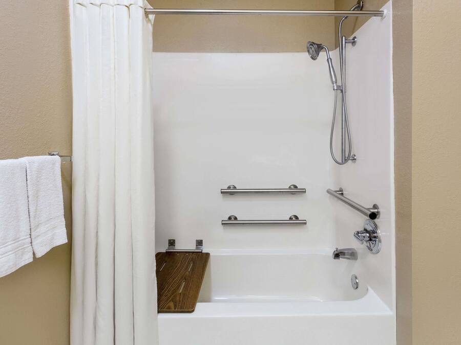 Un bagno con vasca, doccia e porta asciugamani.