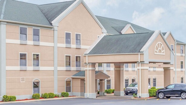 A multi-story hotel with a beige facade, a covered entrance, and a parking lot with cars. - Super 8 by Wyndham Freeport (Freeport)