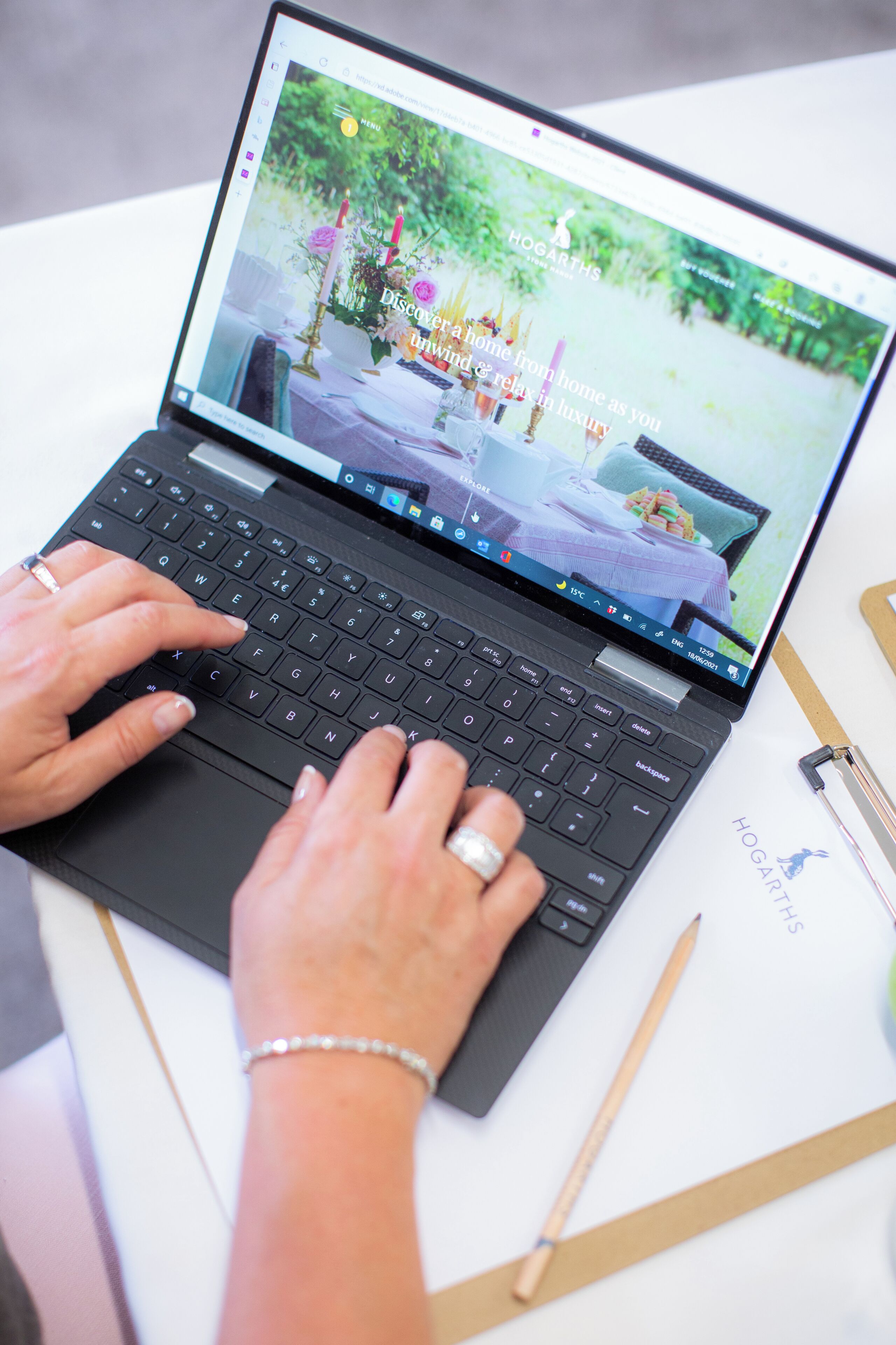 A laptop on a table with a website open displaying a bed and a garden.