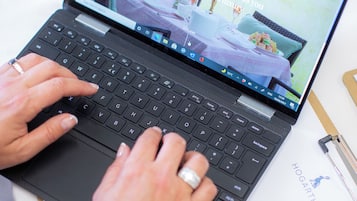 A laptop on a table with a website open displaying a bed and a garden.