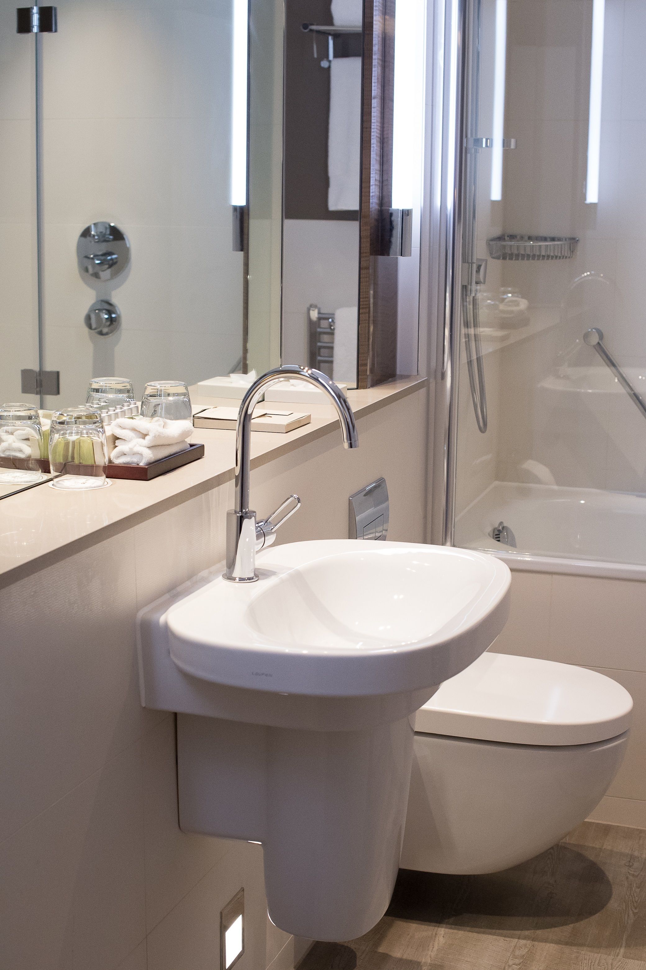 Un baño moderno con lavamanos, inodoro y ducha.