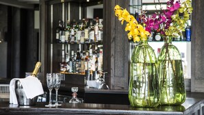 En bar med en champagneflaske, to glas og to grønne vaser med blomster.