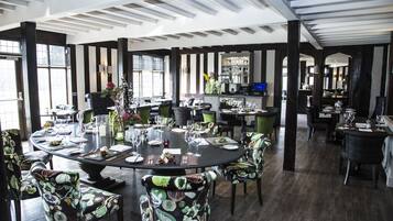 A dining area with a round table set for a meal, surrounded by chairs with patterned upholstery.